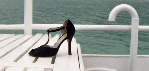 Woman's tongo shoe on a boat.
             The boat is in Lago Argentino
             near Perito Moreno Glacier.
             What is the woman doing?